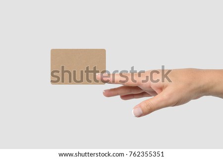 Mockup of female hand holding a Kraft Paper Business Card isolated on light grey background. Rounded corner, size 85 × 55 mm.