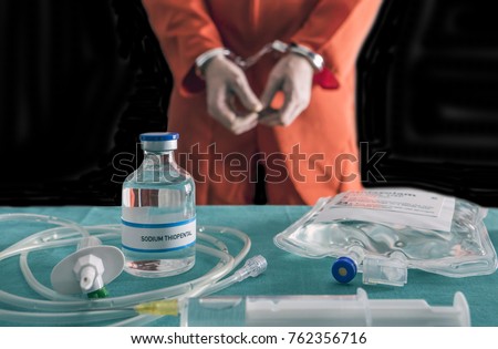 Prisoner handcuffed to death by lethal injection, vial with sodium thiopental and syringe on top of a table, conceptual image Royalty-Free Stock Photo #762356716