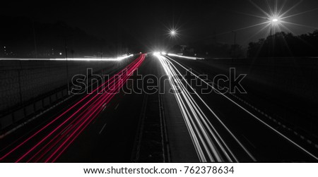 Fast driving vehicles trial at night, with long exposure blurred effect .
