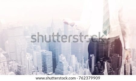 Business man standing on roof with city view in the background