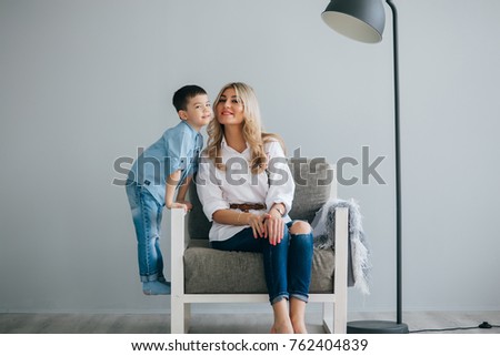 Mom and son are sitting in a chair in a bright room. Mothers Day