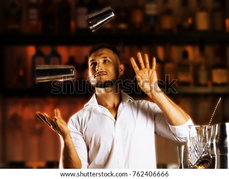 Fantastically beautiful bartender tosses two shakers into the air and arranges a real show for their guests. Mixed media Royalty-Free Stock Photo #762406666