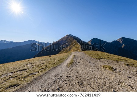 rocky mountain peak area view in slovakia. bright sunlight and white clouds on blue sky covering hills. panoramic view
