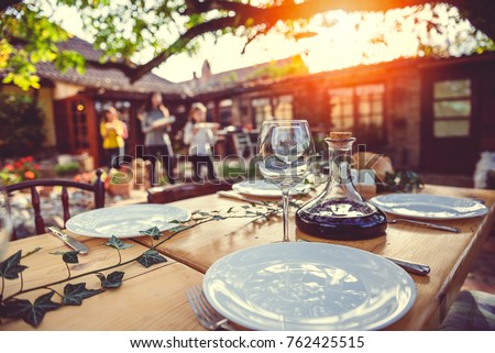 Family together preparing dining table for a lunch at backyard patio Royalty-Free Stock Photo #762425515