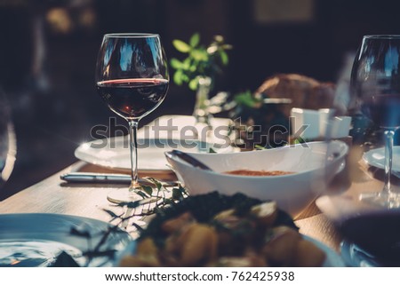 Glass of red wine at dining table in backyard patio