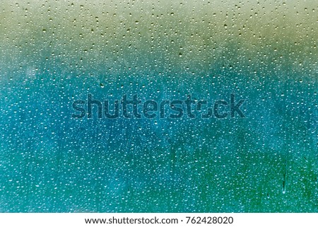drops of rain on a glass on a multicolored background