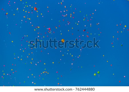 Multicolored balloons fly in the blue sky