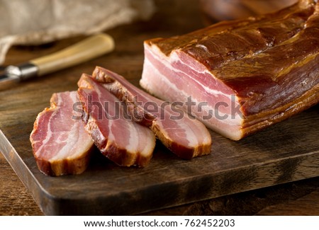 Delicious artisanal whole smoked slab bacon on a cutting block. Royalty-Free Stock Photo #762452203