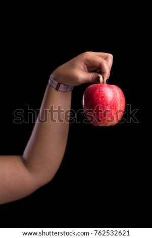 Woman holding red apple on isolate black background