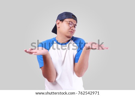 Photo image portrait of a cute funny young Asian man showing something on his open palms, thinking looking and making a choice beetwen hands gesture, empty copy space concept 