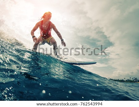 Young surfer rides the ocean wave. Extreme sport and action concept Royalty-Free Stock Photo #762543994