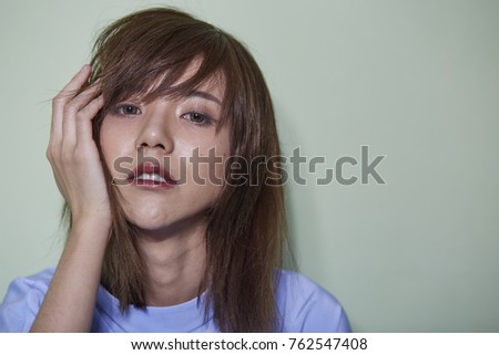 Portrait of short hair Asian girl on light green background.