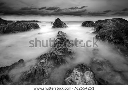 Tropical rocky beach at sunrise in vertical format.( long exposure photography,Soft focus due to long exposure shot. Nature composition ) soft and grain effect

