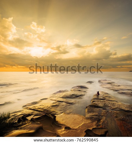 A photographer taking pictures outdoors in the beach.Beautiful scenery with rays of lights. Located in Tips of Borneo, Simpang Mengayau,Kudat, Sabah. 