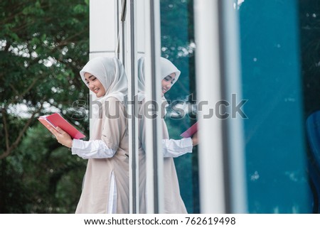 candid portrait of young asian muslim student on campus