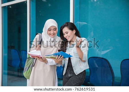 two university students studying together outside her campus