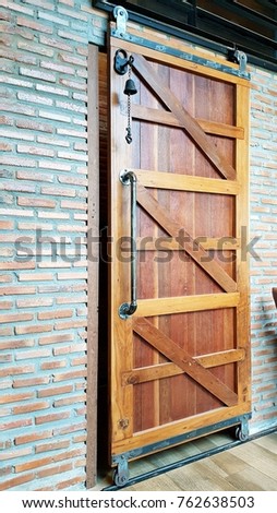 Old wood door slide with brick wall and steel