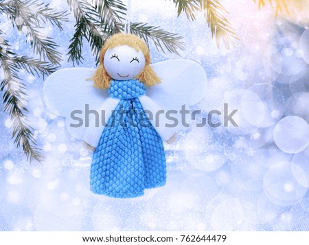 happy angel on branch of tree winter background with snow and snowflakes