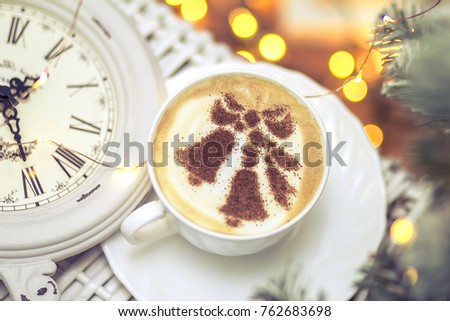 Christmas coffee in a white cup with a picture of a New Year tree from cinnamon on milky foam cappuccino