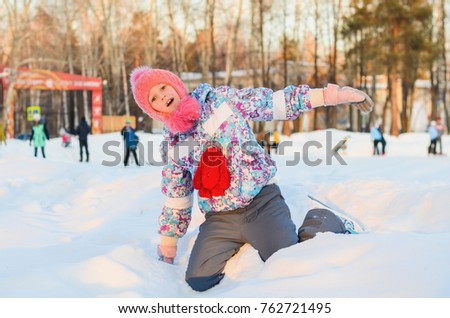 girl skater is in the snow, she poses for the camera
