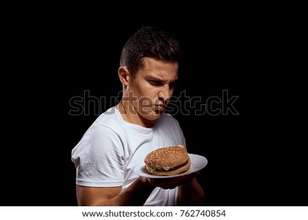 man with a hamburger on a black background                               