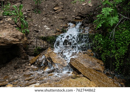 The flow of water on wet stones and grass
