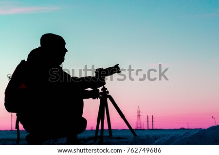 Silhouette of a photographer like to travel and photography, taking pictures of the beautiful moments during the sunset ,sunrise