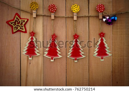 Christmas tree hang by rope and paper clip on wooden background with copy space.