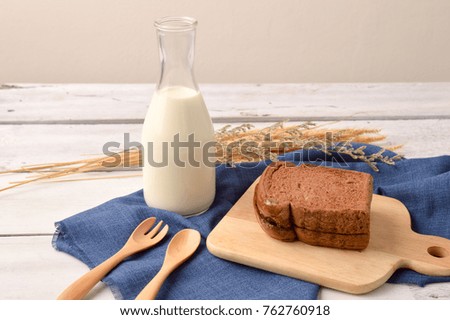 Bread and milk with coffee bean for breakfast on wooden background
