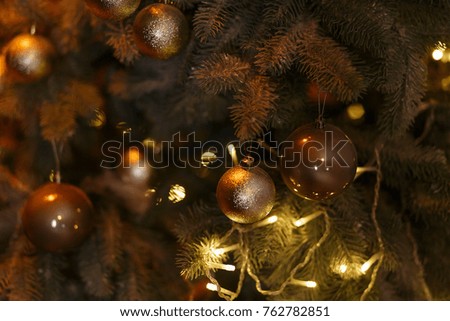 Christmas tree with brown bolls and light garland decorations.