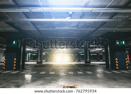 Dark nderground garage or modern car parking with car lights, toned