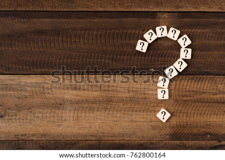 question mark tiles arranged forming bigger question mark. question mark on wooden table background Royalty-Free Stock Photo #762800164