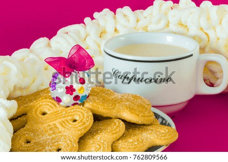 White mug with hot cappuchino, cream scarf and cookie.