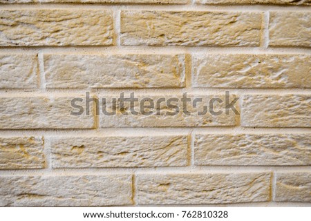 Beige brick wall with beige seams. Large bricks. The background.