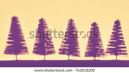 Blurred shadows of miniature Christmas trees, color toning applied.
