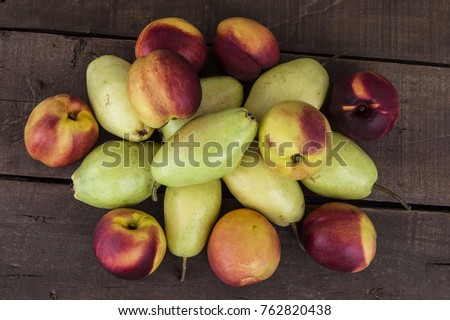 son of summer fruits, ripe pears in dish stands, standing on a wooden floor yellow ripe pears, nectarines and apples pictures,