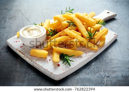 Homemade Baked Potato Fries with Mayonnaise and rosemary on white wooden board Royalty-Free Stock Photo #762822394