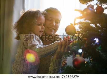 Mother and daughter celebrate Christmas in a decorated house with a Christmas tree
