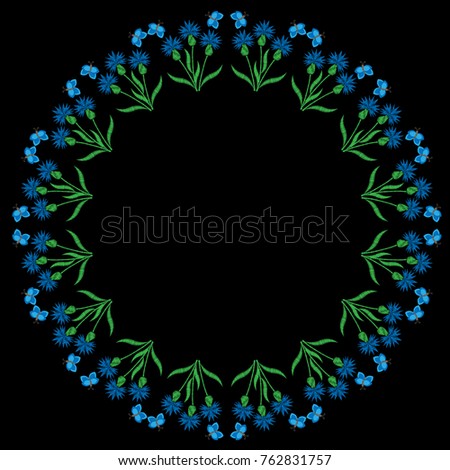 Round frame with blue flower and butterfly embroidery stitches imitation on the black background. Embroidery corn flower circle wreath.