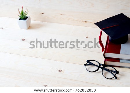 Graduation cap, hat on wood table graduation concept. Royalty-Free Stock Photo #762832858