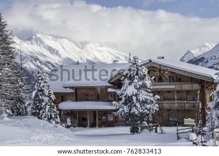 Winter mountain landscape with Alpine house and snowy trees.