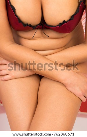 A fat woman holds her stomach.