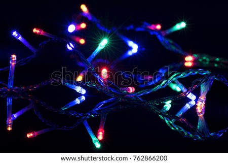 Christmas lights on reflective black background. Holiday shiny garland border. Xmas ligts concept