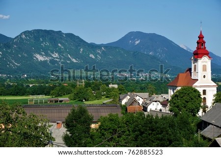 Saint John the Baptist Church Zasip, Slovenia in front of mountain panorama