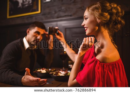 Woman in red dress makes image of her man on phone