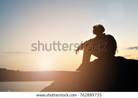 Silhouette of little girl waiting for sunset on top mountain , Happy and relax time