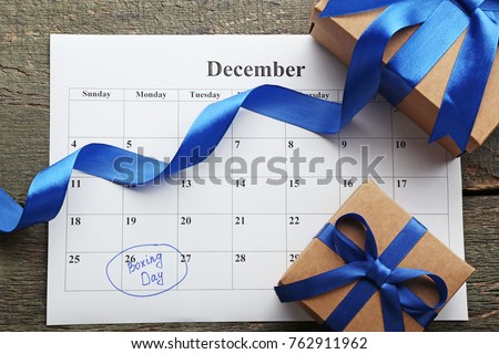 Gift boxes and calendar list on wooden table. Boxing day concept Royalty-Free Stock Photo #762911962