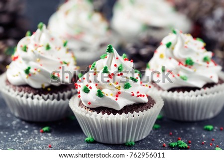 Chocolate cupcake decorated white cream and fir trees. Christmas sweets. New year dessert. Toned picture