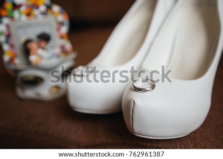 Beautiful wedding rings on the bride's shoes. Wedding. Accessories.