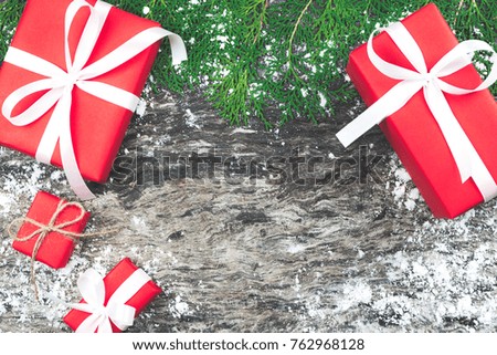 Set of red gift boxes with ribbon and rope bow with decorated element on old and rustic wooden background and snow. Christmas and New Year present decoration in vintage tone on flat lay and top view.